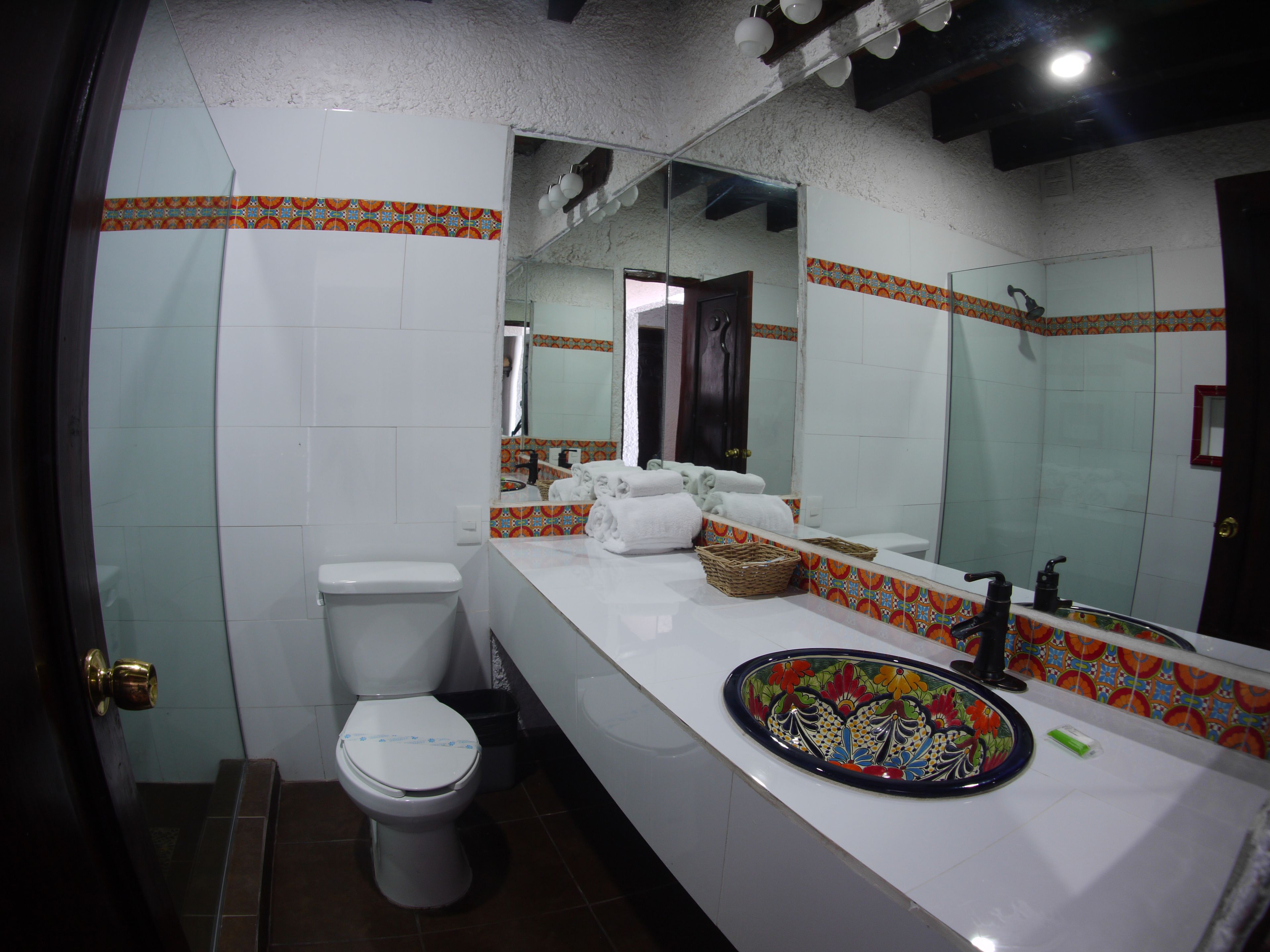 Een badkamer met toilet, wastafel en spiegel.
