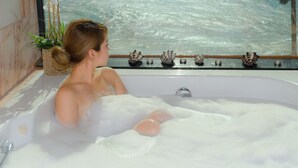 Une baignoire remplie de mousse, une plante en pot et quelques coquillages décoratifs.
