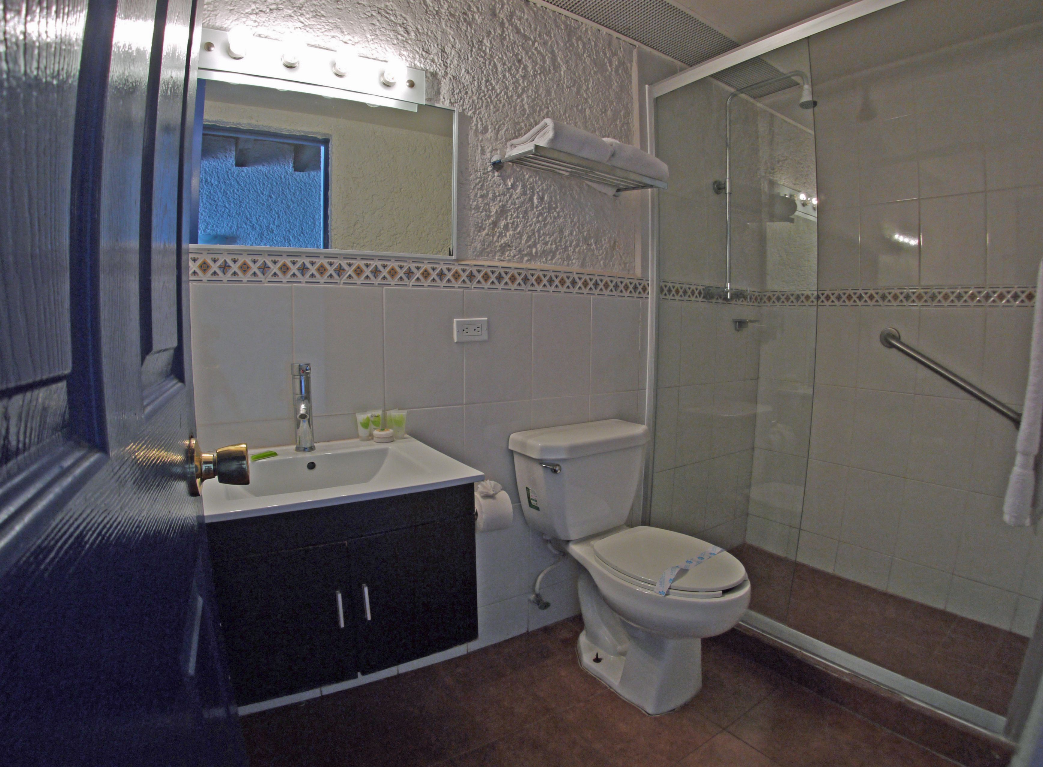 A bathroom with a sink, toilet, and shower.