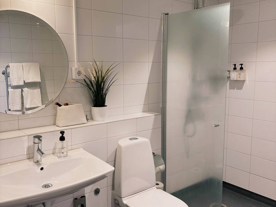 Un baño moderno con inodoro, lavamanos y ducha.