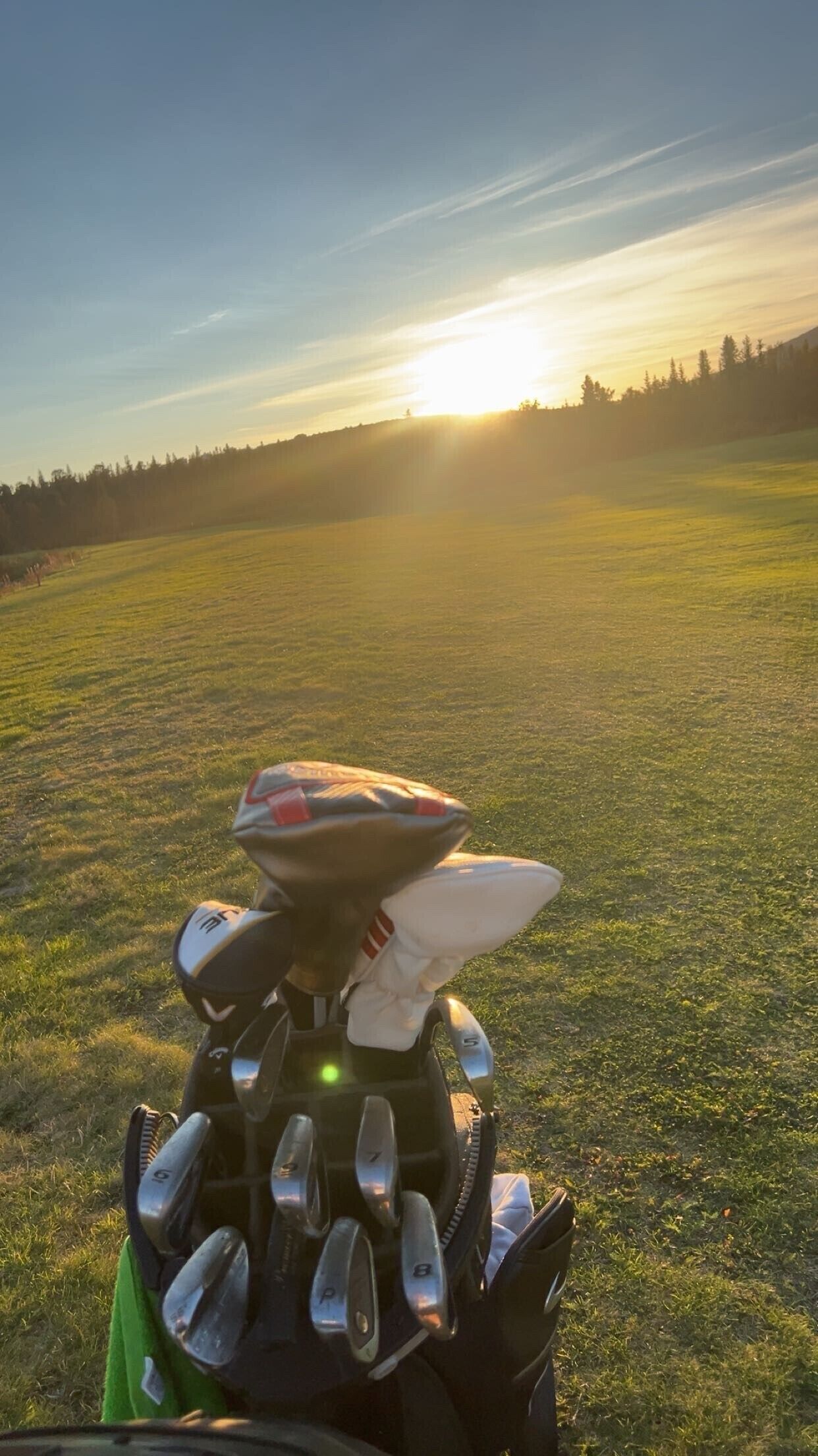 Un casco de motocicleta sobre un campo cubierto de hierba, con un atardecer de fondo.