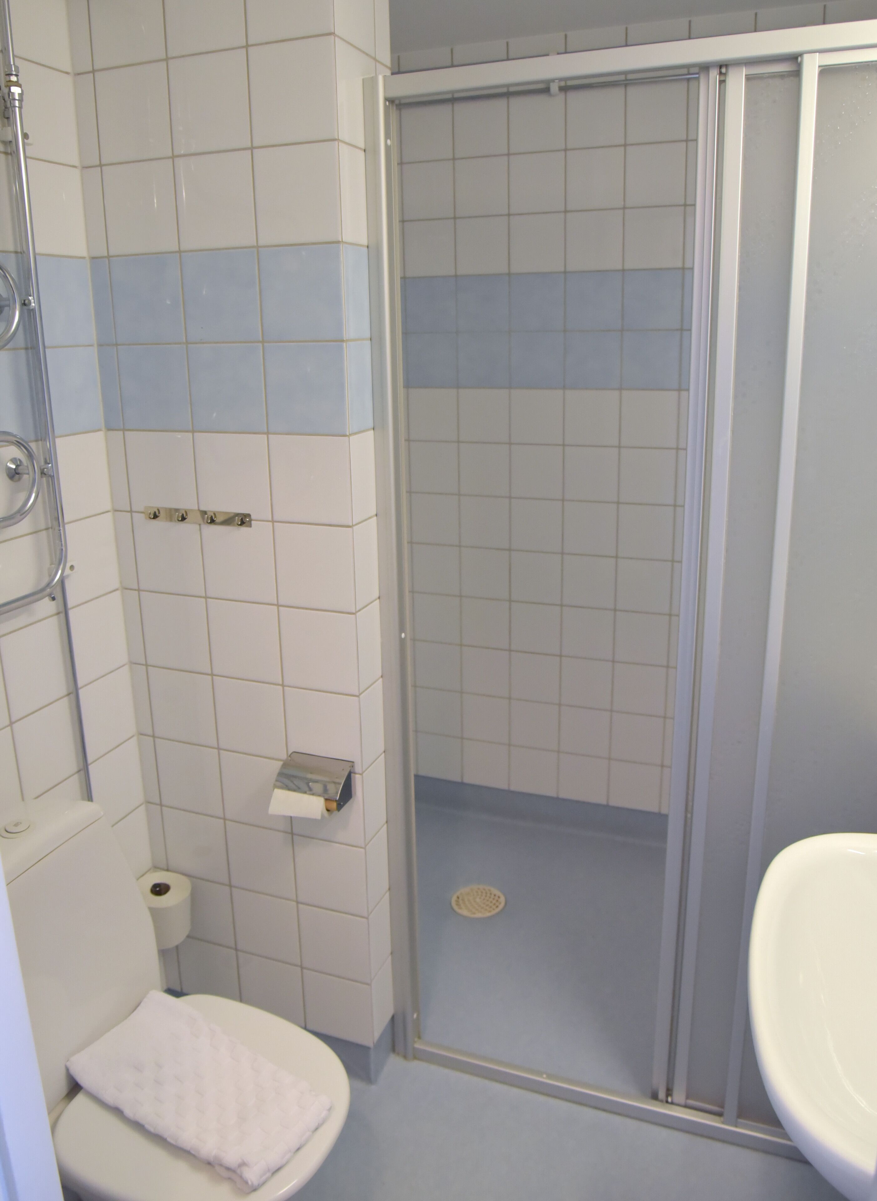 Kylpyhuone, jossa on wc, suihkukaappi ja pesuallas.
