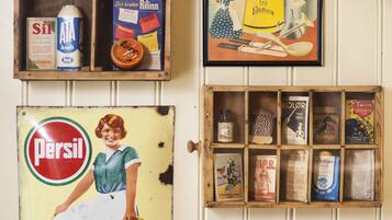 A wall with vintage advertisements and a framed picture.