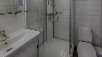 A bathroom with a glass-enclosed shower, a white sink, and a toilet.