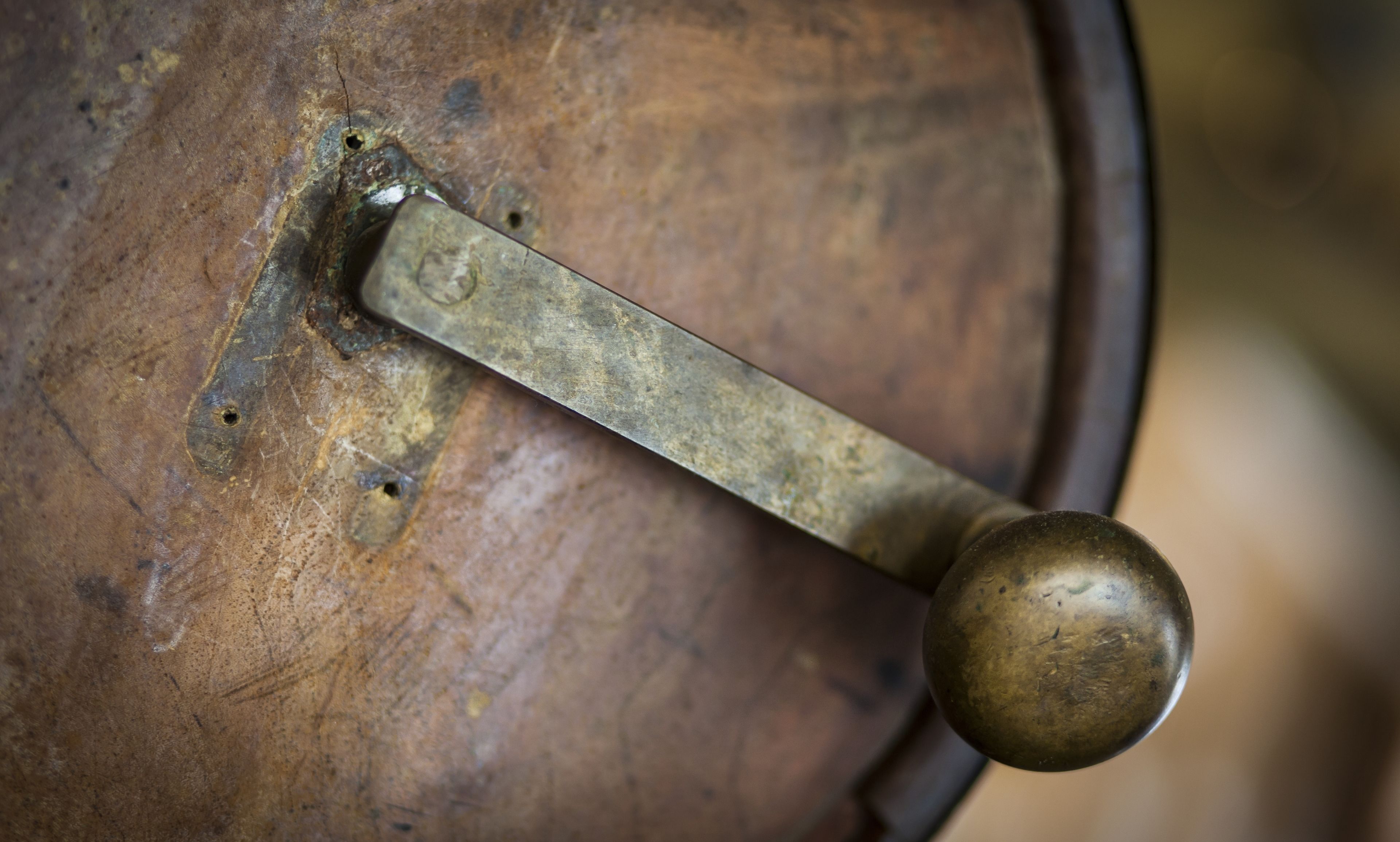 Gros plan d’une poignée de porte en laiton sur une surface en bois.