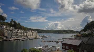A harbor with boats docked, a marina, and buildings along the waterfront.