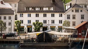 Un hotel sul lungomare con un'area coperta per imbarcazioni e una facciata in stile europeo.