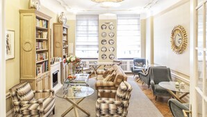 A well-lit living room with a sofa, armchairs, a coffee table, and a bookshelf. - Hotel Elba am Kurfürstendamm - Design Chambers (Berlin)