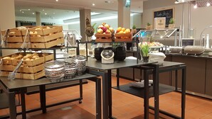Una mesa de buffet con diversos alimentos y utensilios para servir.