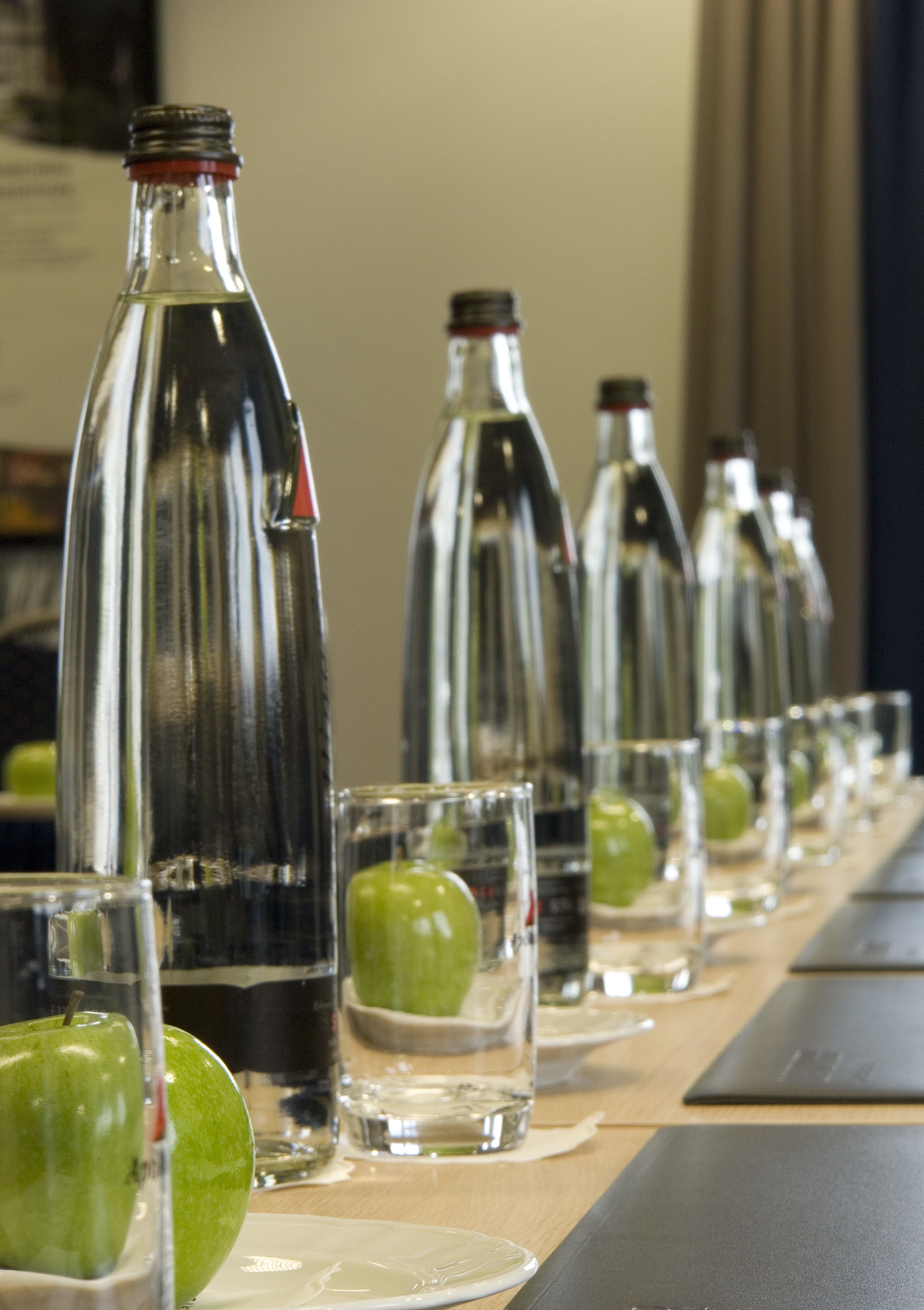 A row of empty bottles and glasses on a table.