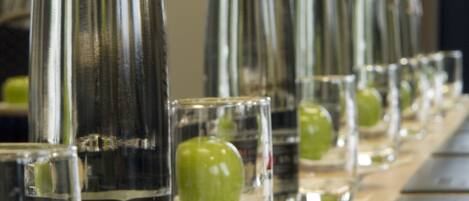 A row of empty bottles and glasses on a table.