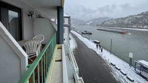 A balcony with a view of a snow-covered river and boats. - Hotel Rheinlust (Boppard)