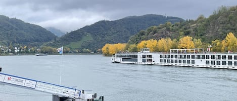 A river with a large white boat docked at a pier.