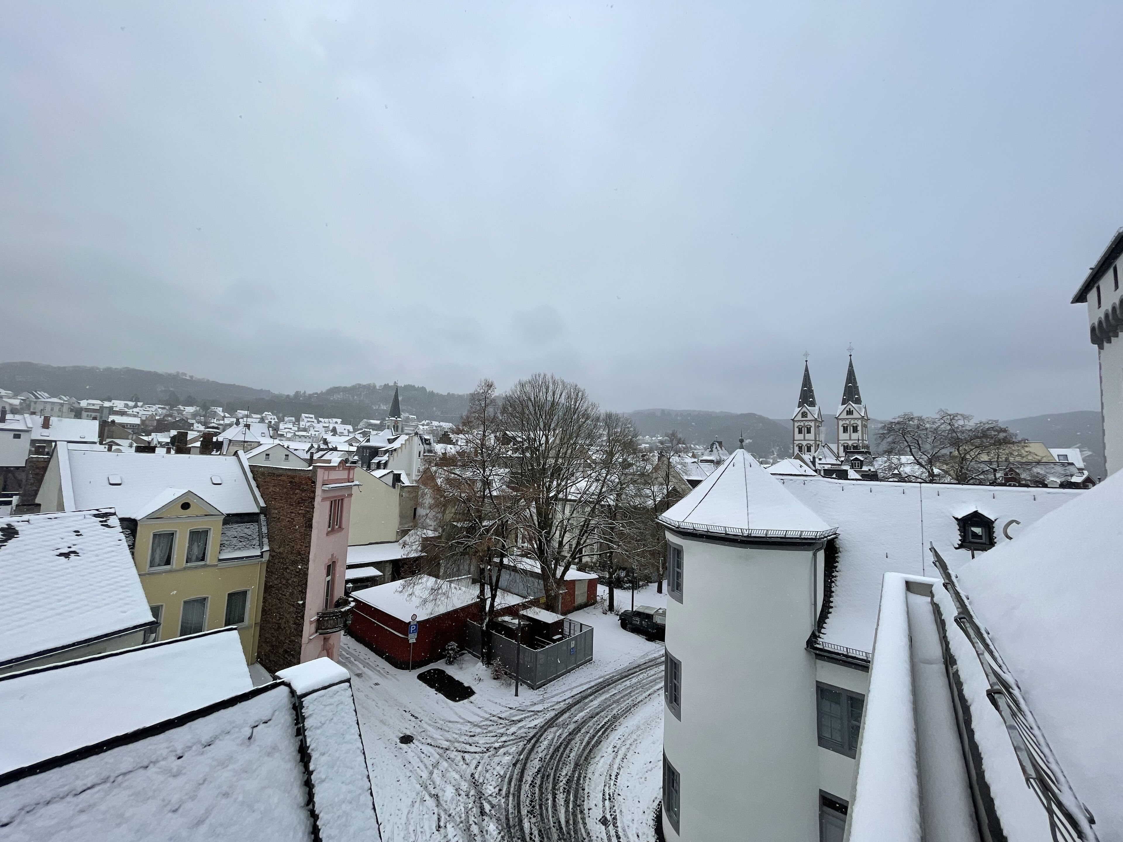 Un barrio residencial cubierto de nieve, con edificios y una iglesia.