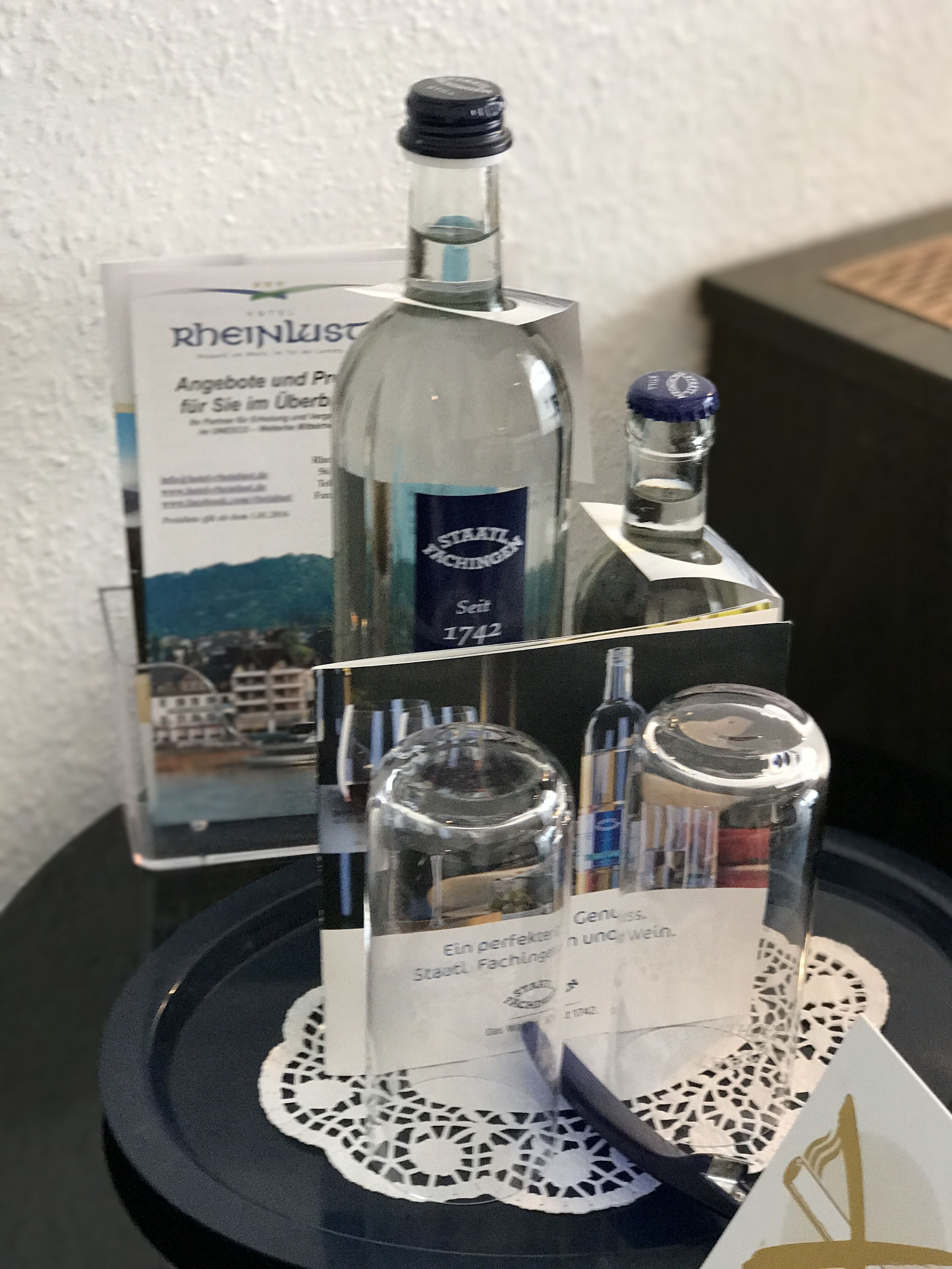 Exposició de botelles amb etiquetes, una petita nostra i una placa amb text.
