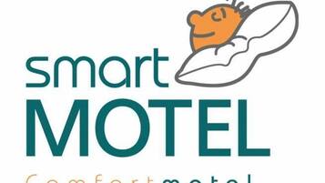 Ein Logo für 'Smart Motel Comfort Motel' mit einer stilisierten Illustration einer Katze und eines Kissens.