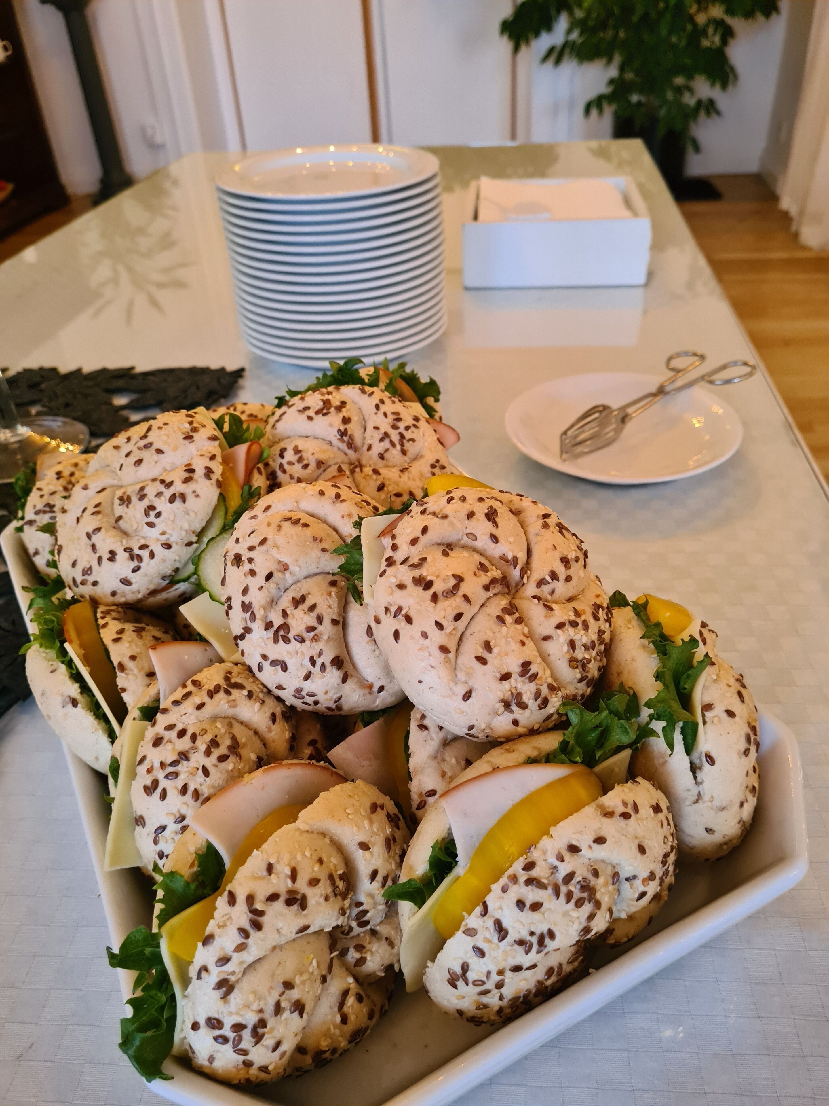 Una bandeja de bagels con queso crema y verduras sobre una mesa.