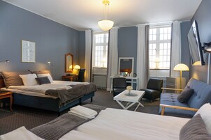 Una habitación de hotel con cama, escritorio, silla y sofá.