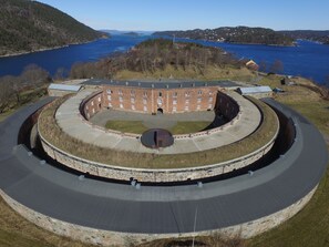 A circular building with a central courtyard, surrounded by a stone wall and a paved walkway.