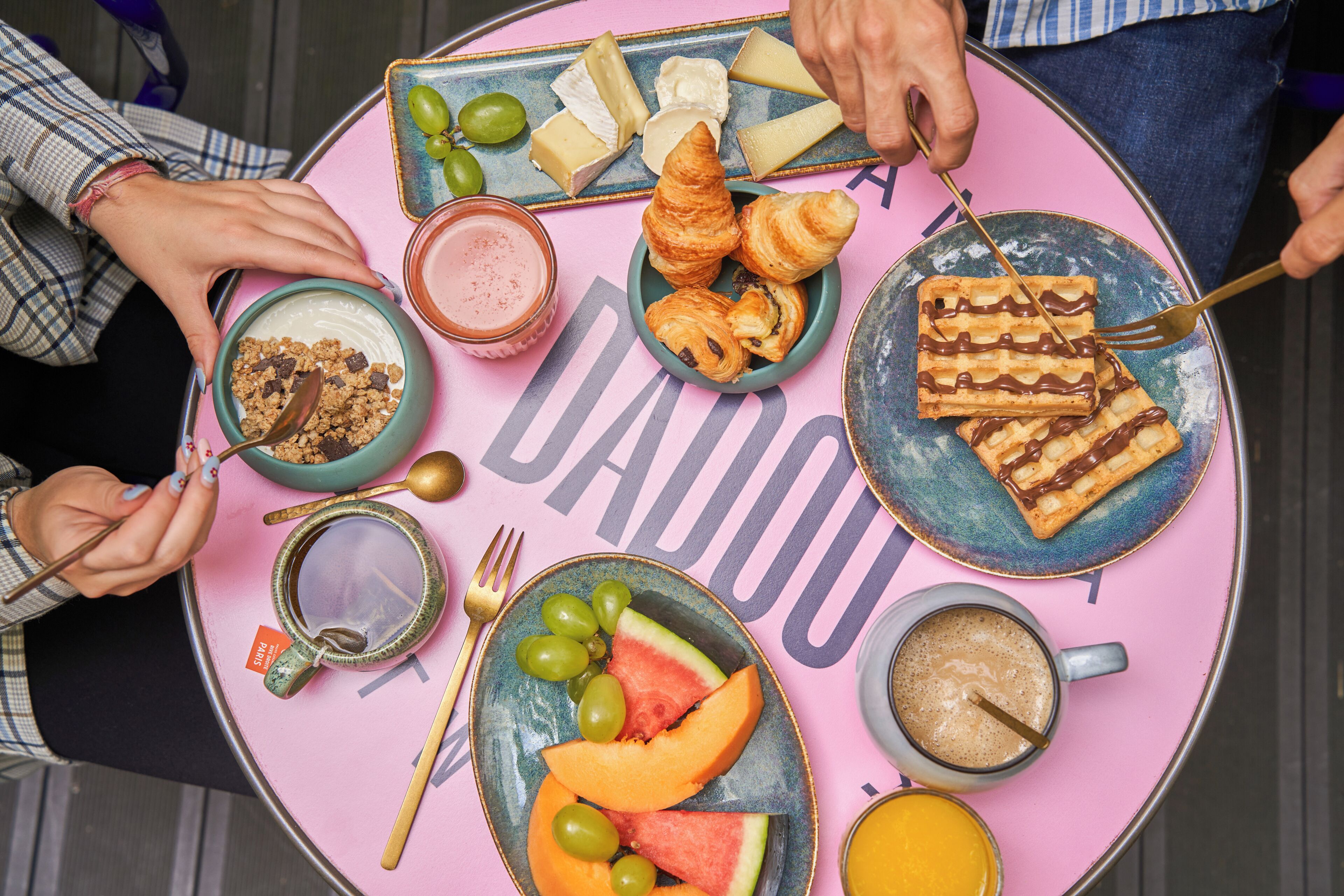 A round table with various food items and utensils, indicating a dining setup.