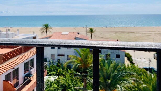 Un balcón con vista a una playa y al océano.