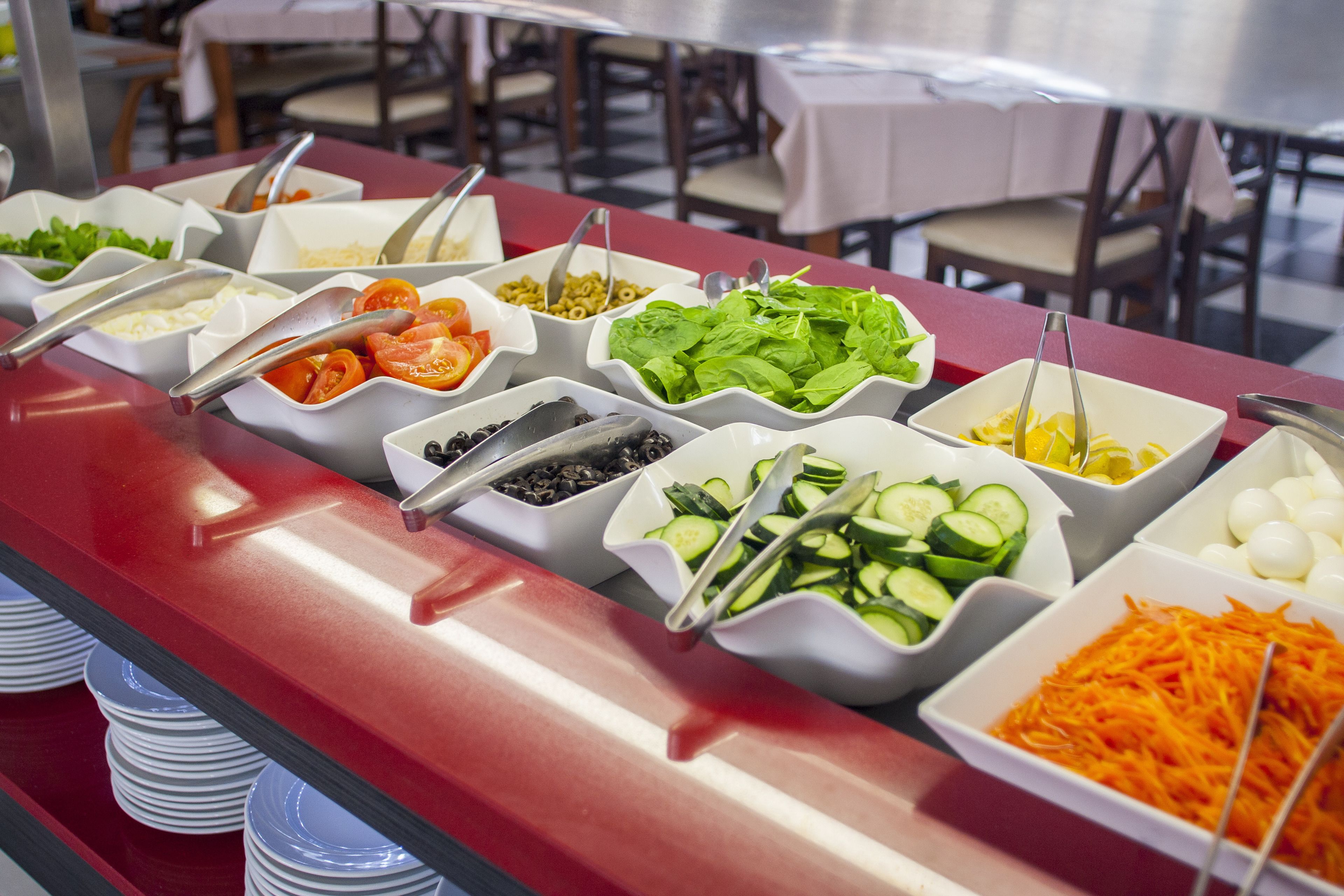A buffet with various food items including vegetables, cheese, and eggs.
