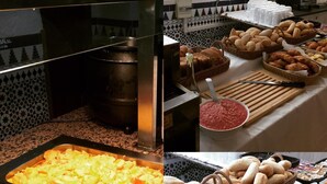 Un bufé con diversas opciones de comida, incluyendo tocino, huevos revueltos, pan y pastelería.
