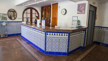 A reception area with a tiled counter, a clock, and a door.