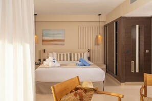 A hotel room with a bed, a wooden chair, a woven bag, and a painting on the wall. - AQUA Hotel The Breeze & Spa - All Inclusive - Adults Only +18 (Santa Susanna)