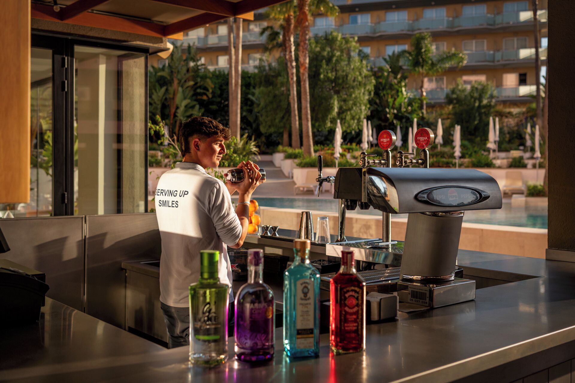 A bar area with a bartender, a coffee machine, and various bottles of alcohol.