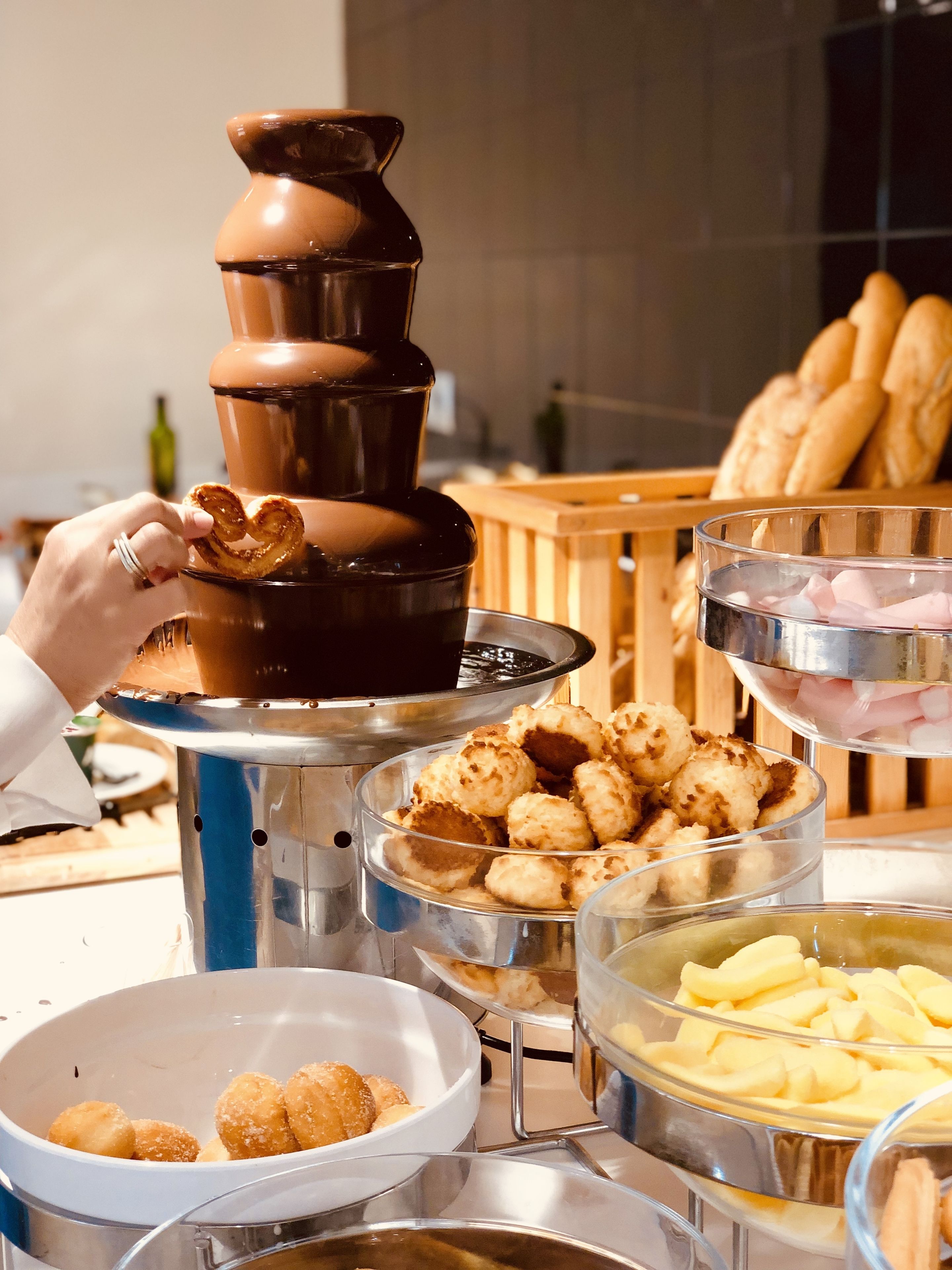 A buffet setup with various food items including pretzels, tater tots, and other snacks.
