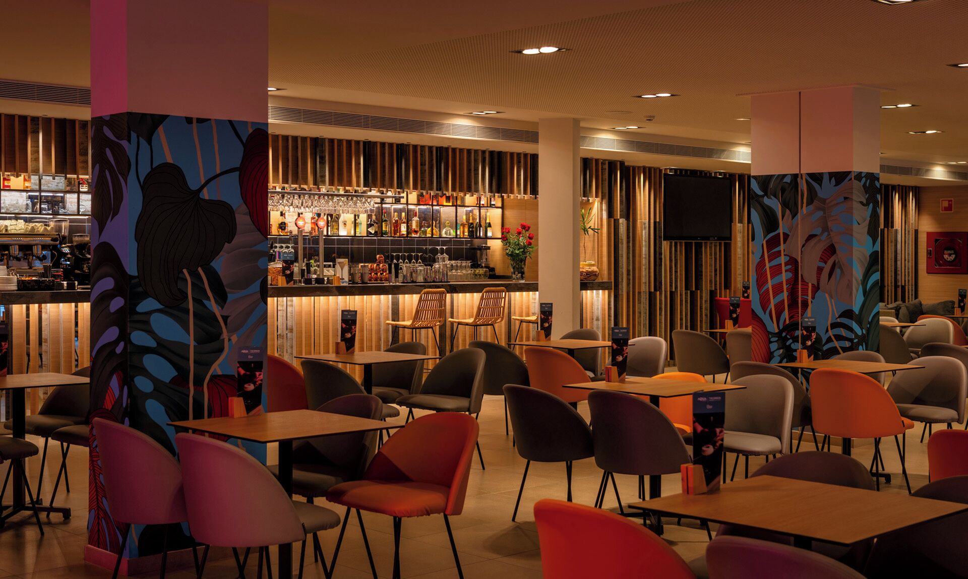 A modern bar area with a variety of seating options and a bar stocked with bottles.