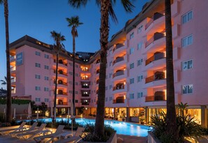 A multi-story hotel with balconies, a swimming pool, and palm trees. - AQUA Hotel The Breeze & Spa - All Inclusive - Adults Only +18 (Santa Susanna)