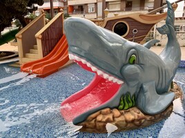 Una piscina al aire libre, sillones reclinables de piscina