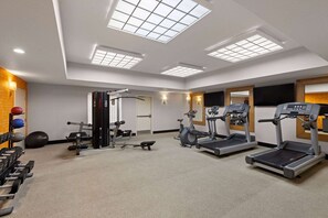 A gym with treadmills, elliptical machines, and weightlifting equipment. - La Quinta Inn and Suites by Wyndham at WaTiki Waterpark (Rapid City)