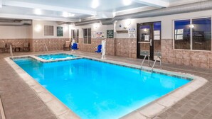 An indoor swimming pool with clear water, surrounded by tiled walls and a ceiling with visible ductwork. - La Quinta Inn & Suites by Wyndham Rifle (Rifle)