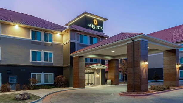 A hotel with a modern design, featuring a prominent 'La Quinta' sign, a covered entrance, and a well-lit facade. - La Quinta Inn & Suites by Wyndham Rifle (Rifle)