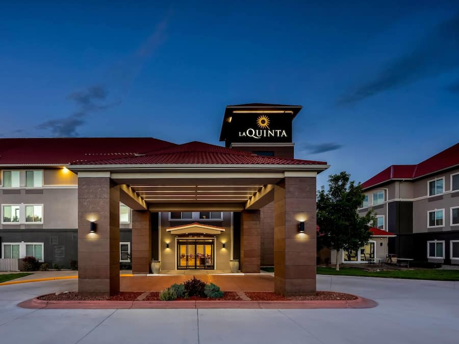 A hotel entrance with a covered walkway, a red roof, and a sign reading 'La Quinta'.