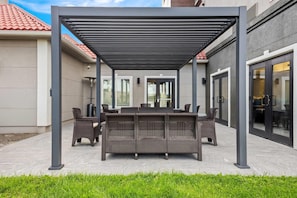 An outdoor patio with a covered seating area, a table, and chairs. - La Quinta Inn & Suites by Wyndham Rifle (Rifle)