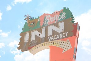 A vintage sign with a deer and trees, indicating a motel named "Breck" with a vacancy sign.