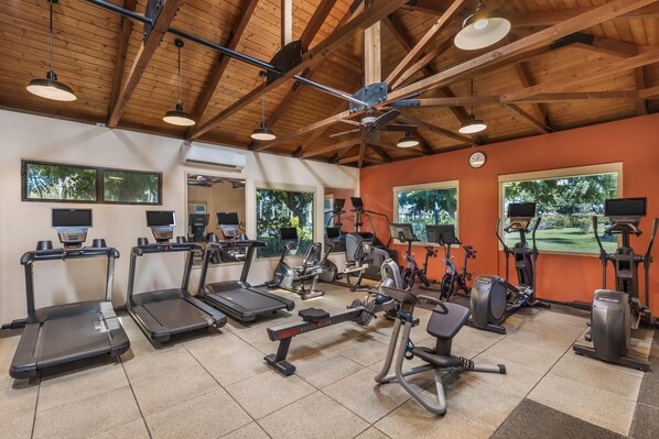 Une salle de sport équipée de tapis de course, d’appareils elliptiques et de vélos d’appartement.