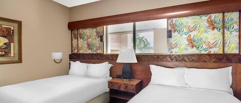 A hotel room with two single beds, a nightstand with a lamp, a large mirror, and a painting on the wall.