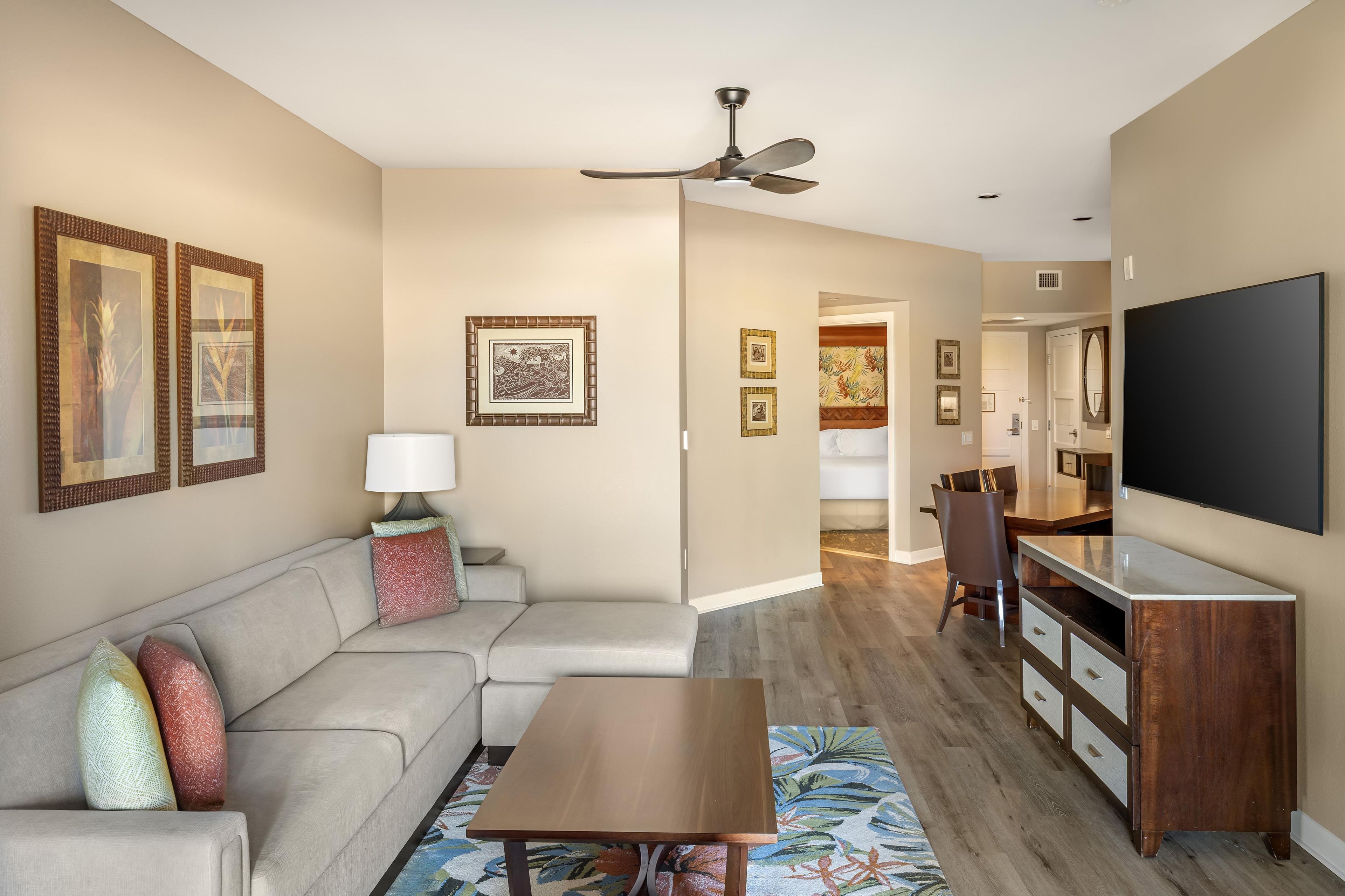A modern living room with a sofa, coffee table, and a flat-screen TV.