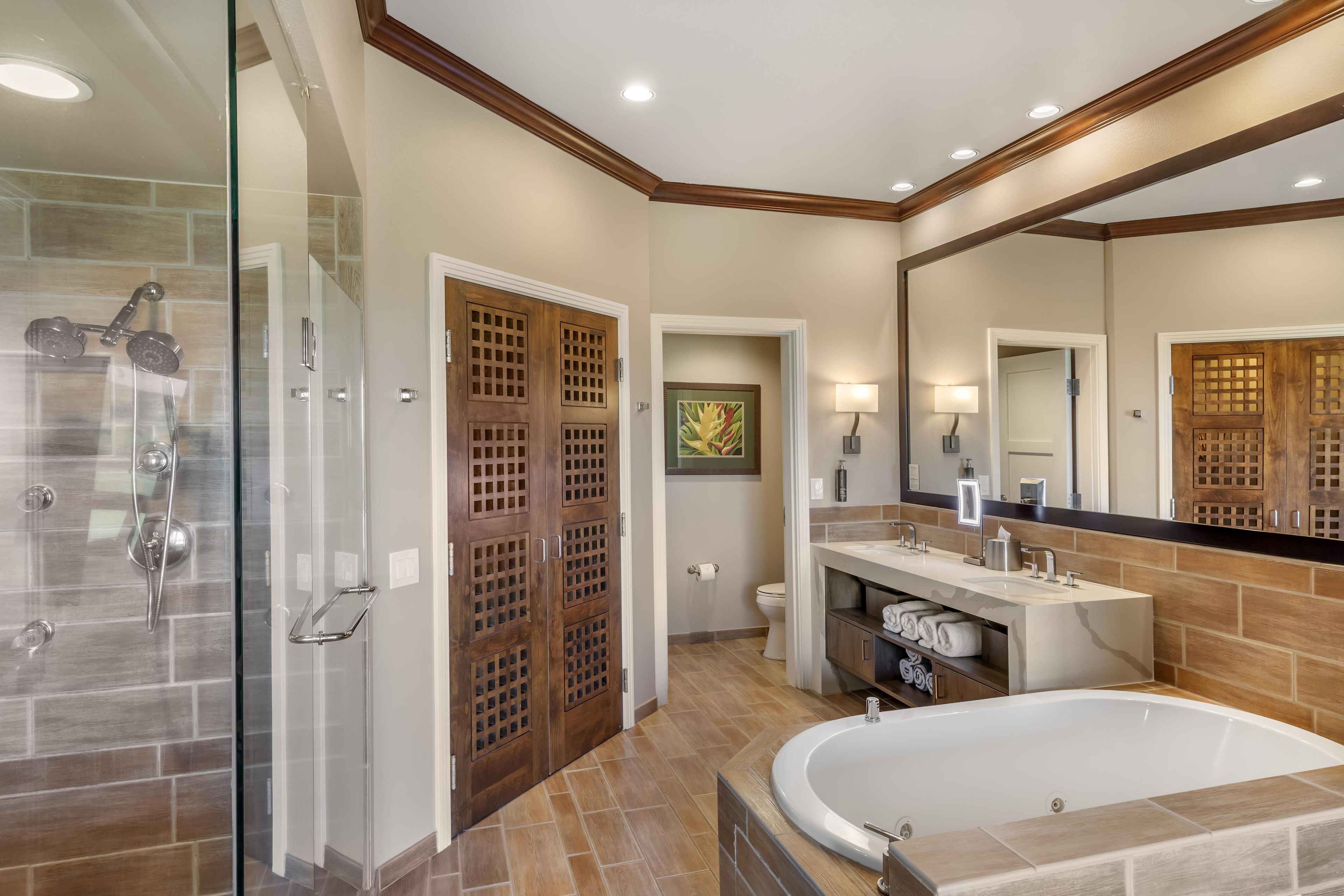 Une salle de bain moderne dotée d’une douche à parois de verre, d’une baignoire sur pieds et d’un meuble-lavabo avec un miroir.