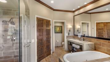 Une salle de bain moderne dotée d’une douche à parois de verre, d’une baignoire sur pieds et d’un meuble-lavabo avec un miroir.