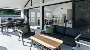 Un espace de vie moderne, à aire ouverte, comprenant un coin repas, un canapé et une table basse.