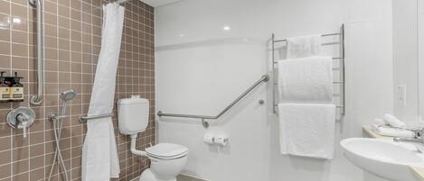 A modern bathroom with a shower, toilet, and sink.