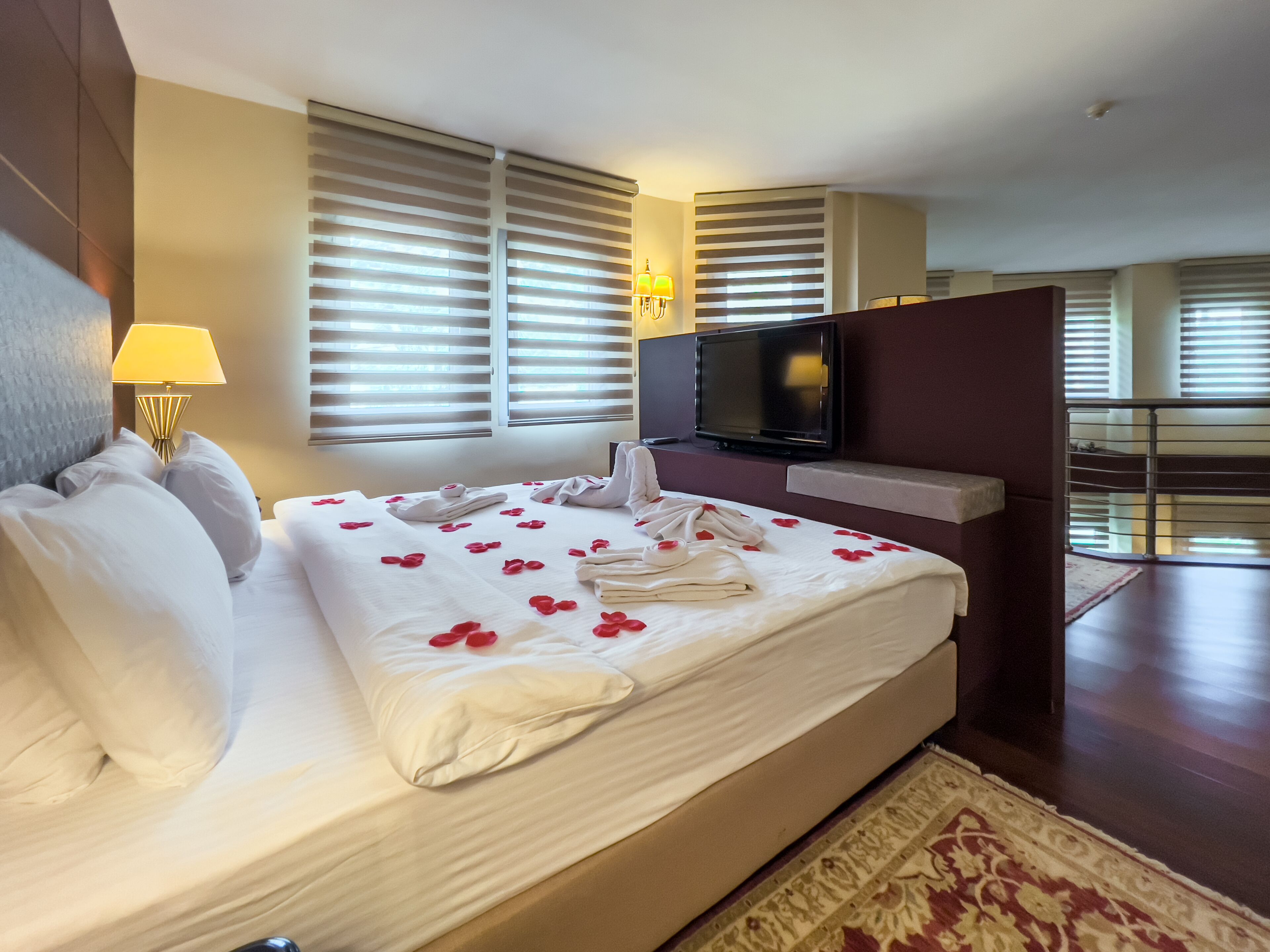 Quarto de hotel com uma cama grande, televisão e varanda.