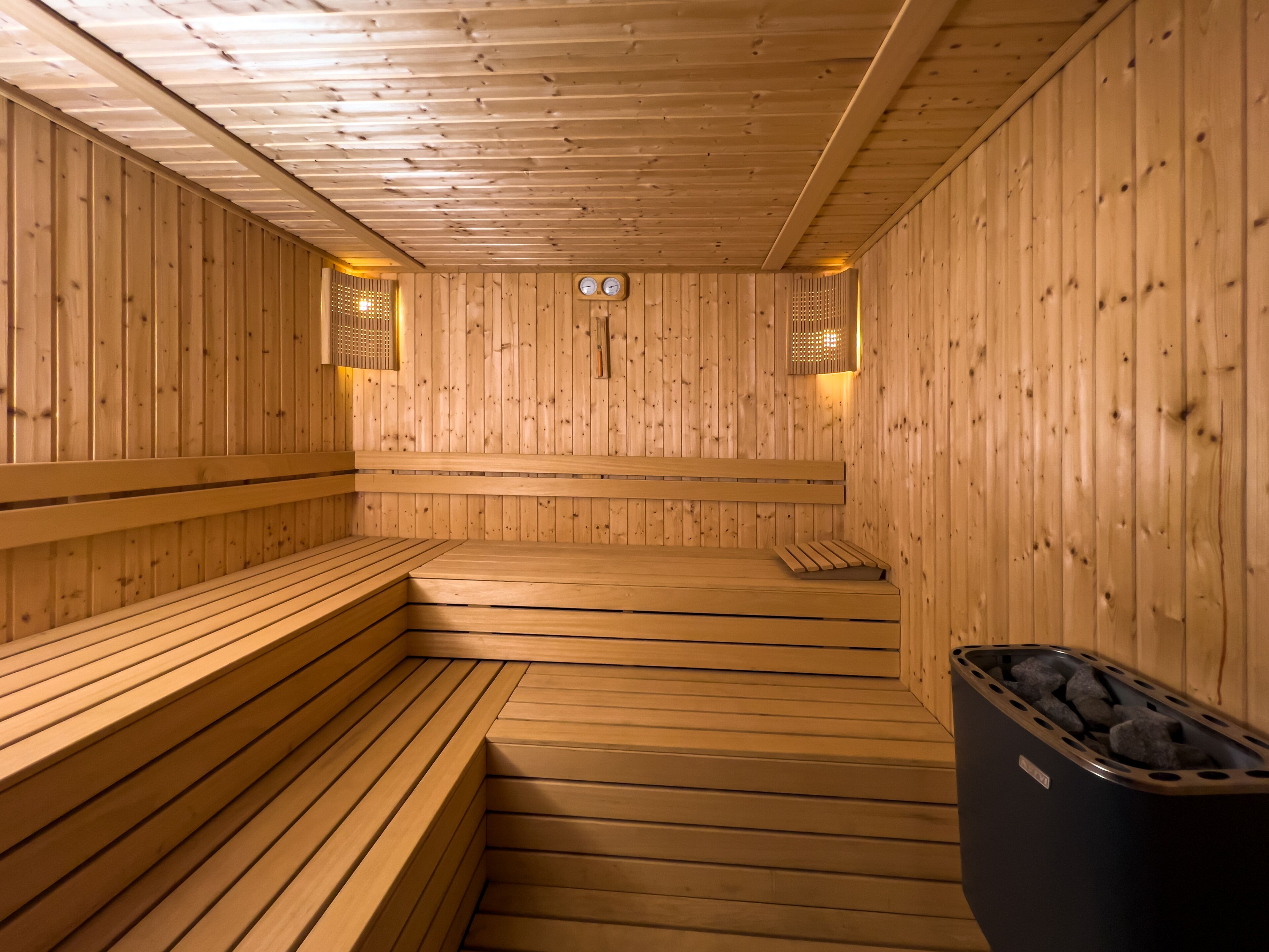 Una sauna de madera con bancos y un cubo de basura.