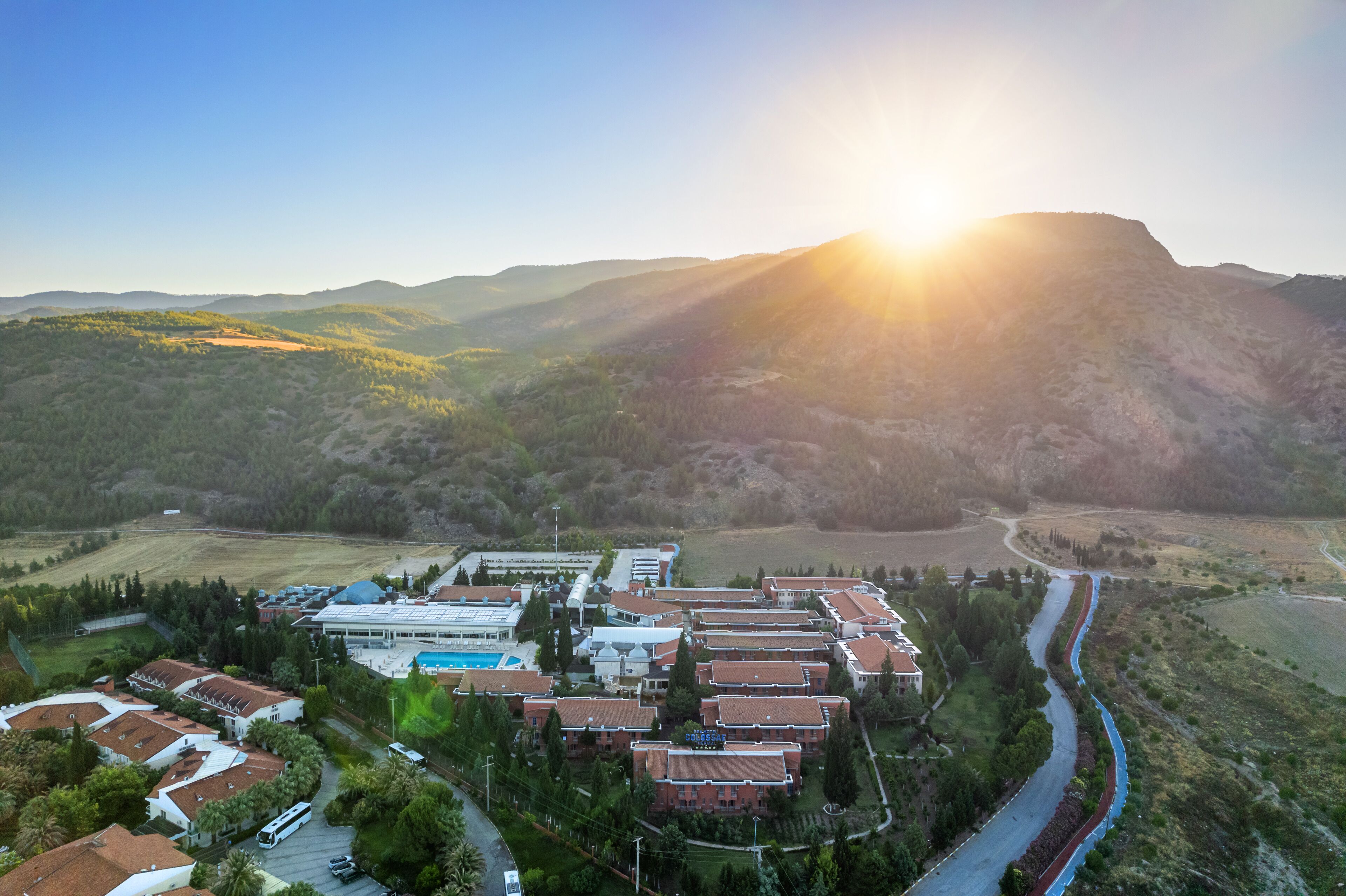 A resort with multiple buildings, a swimming pool, and a river.